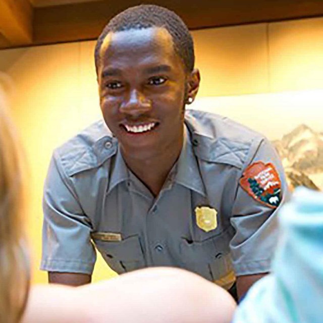 A park ranger helps a little girl.